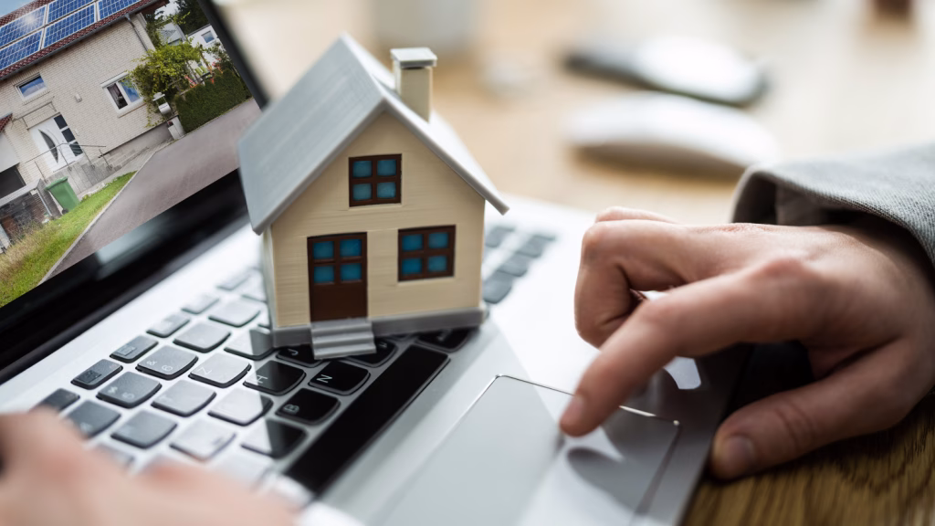 Modellhaus auf einer Laptop-Tastatur bei der Immobiliensuche